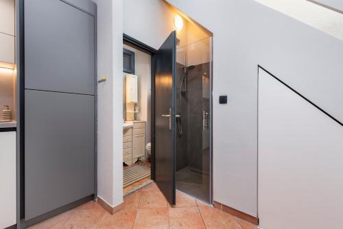 a bathroom with a shower and a glass door at Atrium Town House in Rovinj
