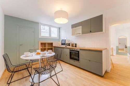 une cuisine et une salle à manger avec une table et des chaises dans l'établissement Le Waterloo - Au coeur de Nantes, à Nantes