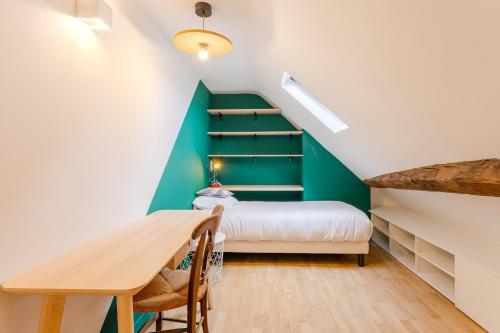 - une petite chambre mansardée avec un lit et une table dans l'établissement Le Waterloo - Au coeur de Nantes, à Nantes