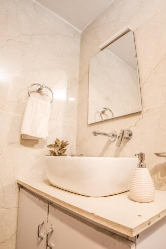 un bagno con un lavandino bianco e uno specchio di Pebbles Cottage by EdenHomes a Manāli