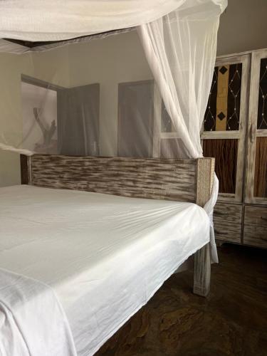 Un dormitorio con una cama blanca con dosel. en Villa Morosa, en Watamu