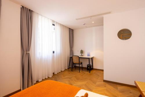 a room with a table and a curtain and a desk at Wuzhen Xizha Slow Life Riverside Inn in Wujiaqiao