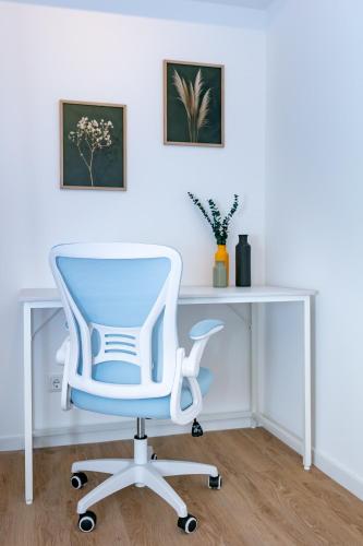 a white desk with a blue chair in a room at CABANA - Deluxe City-Center - kostenloser Parkplatz - Balkon - WiFi - Zentral in Oldenburg