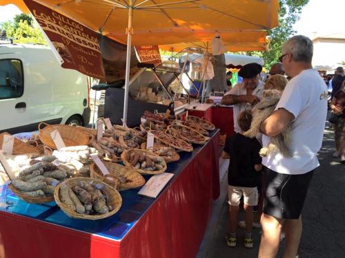 Un homme debout devant une table avec de la nourriture sur elle dans l'établissement Maison de vacances semi climatisée, 4 pièces 4-5 couchages, seulement 80m de la plage de PORTIRAGNES PLAGE LRCLOS10, à Portiragnes