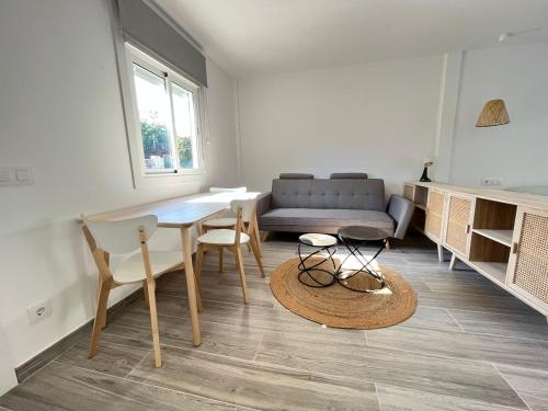 Una sala de estar con una mesa y sillas y un sofá. en Beautiful renovated studio, en Castelldefels