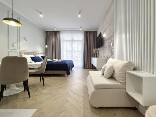 ein Schlafzimmer mit einem Bett, einer Couch und einem Sessel in der Unterkunft Baltic Home in Świnoujście