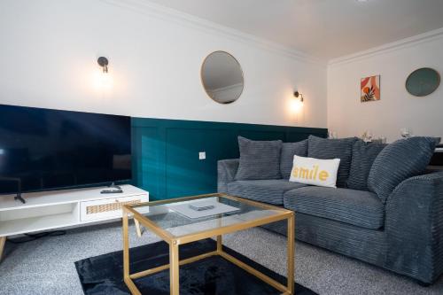 a living room with a couch and a table at Runway Hse Luxe 5 Bed, with King sized Beds, next to Aiport & NEC, JLR 5 mins in Marston Green