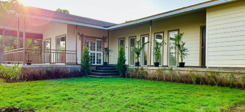 a house with a green lawn in front of it at Mango Shack Villa in Trimbak