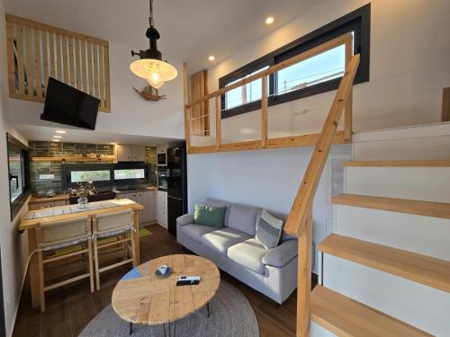 a tiny house with a staircase and a living room at Lagom Retreat - ASKOS in Agios Nikolaos