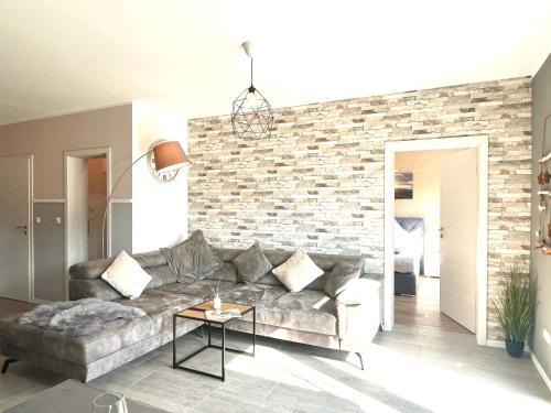 a living room with a couch and a brick wall at Ferienwohnung Sonnenterrasse, 1-4 Personen, 2 Schlafzimmer, große Terrasse in Müden