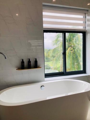 a white bath tub in a bathroom with a window at Fan's Hotel Baybay in Baybay