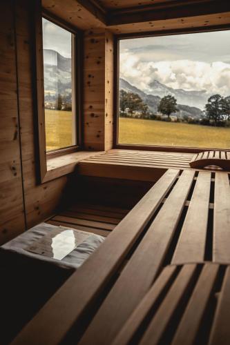 a wooden bench in a room with a window at HELD - Hotel & Spa , 4 Sterne Superior, Zillertal in Fügen