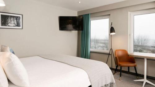 a bedroom with a bed and a desk with a computer at Marine Hotel Ballycastle in Ballycastle
