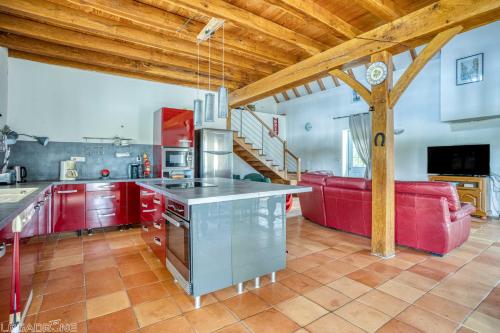 une cuisine avec des placards rouges et un canapé rouge dans l'établissement Authentic Charming House WIFI Swimming Pool 10 ppl, à Beaumont-du-Périgord