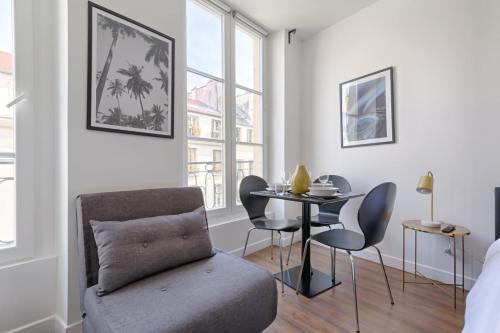un salon avec une chaise et une table dans l'établissement TBS 313 - Elegant studio near Marais district, à Paris