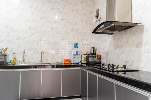 a kitchen with stainless steel cabinets and a sink at Hi-Tea HomeStay in Sungai Petani
