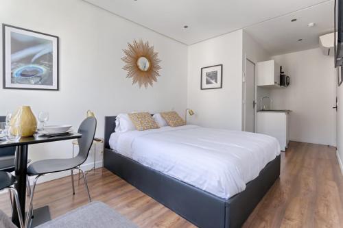 une chambre avec un lit, un bureau et une table dans l'établissement TBS 313 - Elegant studio near Marais district, à Paris