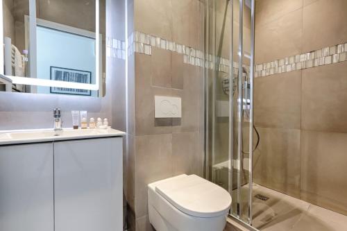 une salle de bain avec toilettes et douche en verre dans l'établissement TBS 313 - Elegant studio near Marais district, à Paris