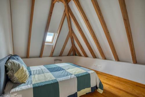 une chambre avec un lit dans un grenier dans l'établissement Authentic Charming House WIFI Swimming Pool 10 ppl, à Beaumont-du-Périgord