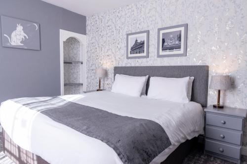 a bedroom with a large bed with white sheets at Cromwell Lodge Hotel by Greene King Inns in Banbury