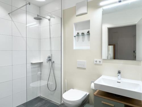 a bathroom with a shower and a toilet and a sink at YUVA HOMES Germering - 100m2 - nahe München - 2 Bäder - Garten&Terrasse - S-Bahn in Germering