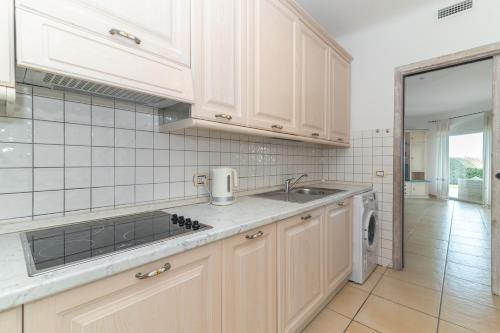a kitchen with white cabinets and a sink at Villa Maddalena in Porto Rafael