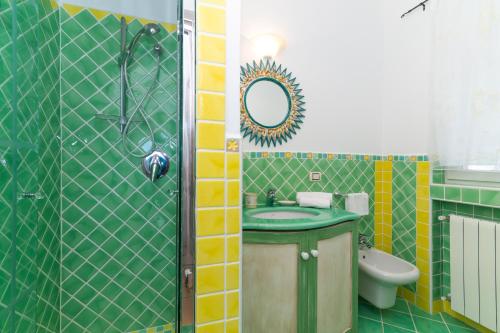 a bathroom with a sink and a shower with a mirror at Villa Maddalena in Porto Rafael
