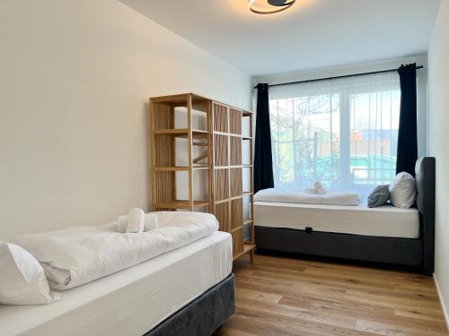 a bedroom with two beds and a window at YUVA HOMES Germering - 100m2 - nahe München - 2 Bäder - Garten&Terrasse - S-Bahn in Germering