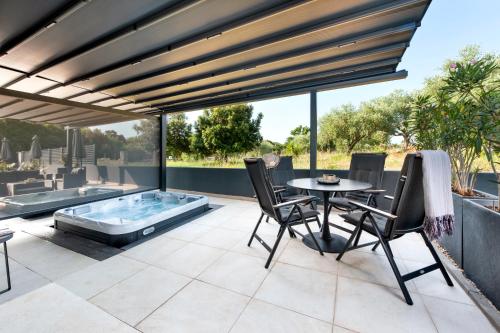 a patio with a table and chairs and a hot tub at Apartments with private jacuzzi Garbin 1 and Garbin 2 in Rovinj
