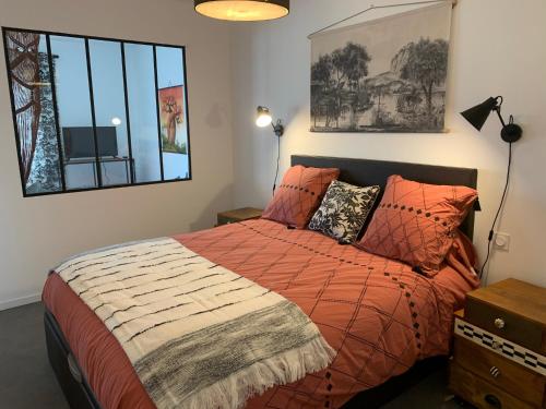 - une chambre avec un lit doté d'une couette en orange et d'une fenêtre dans l'établissement PETIT HAVRE DE PAIX, à Vergèze