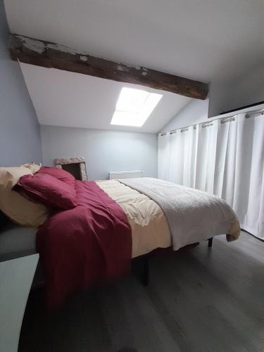 une chambre avec un grand lit dans une pièce dans l'établissement Maison bourguignonne, à Lugny