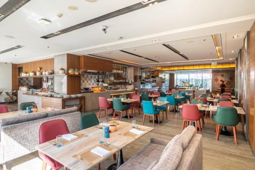ein Restaurant mit Holztischen und bunten Stühlen in der Unterkunft Courtyard by Marriott Amritsar in Amritsar
