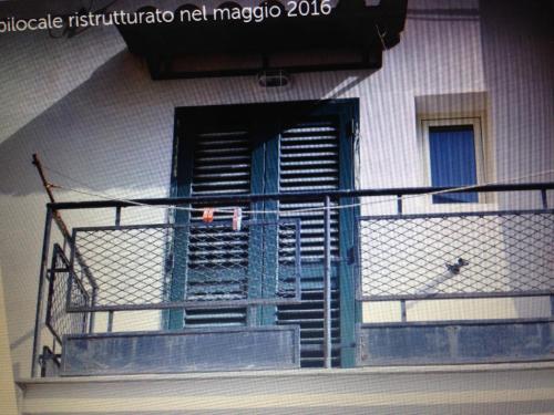 a balcony with a blue door and a railing at Fiordaliso in Caulonia Marina