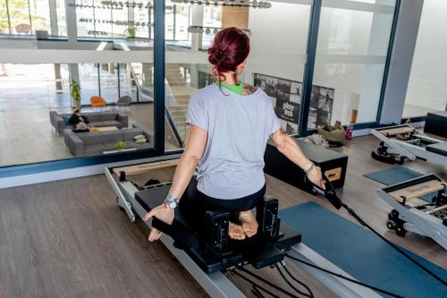 a woman on a pilates reformer in a gym at Playitas Hotel - Sports Resort in Las Playas