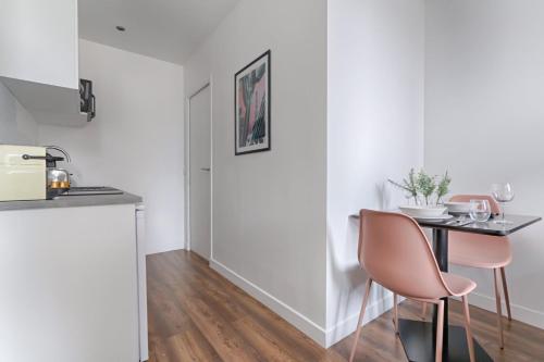 une cuisine avec une table et des chaises dans une pièce dans l'établissement TBS 314 - Bright studio near Marais district, à Paris