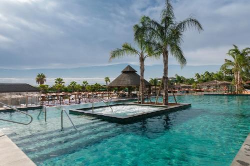 a pool at a resort with palm trees and chairs at La Marina Resort in La Marina