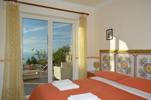 a bedroom with a bed and a large glass window at Le Ginestre di Capri BB & Holiday House in Anacapri