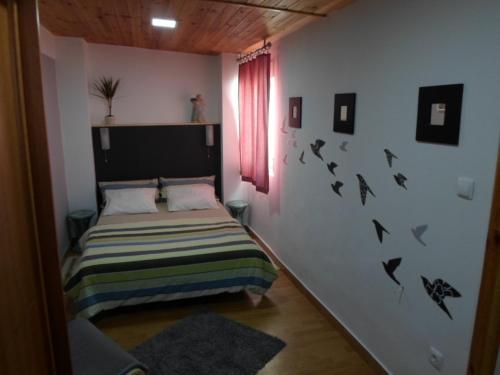 a bedroom with a bed with birds on the wall at Casa Beco Sao Luis in Faro