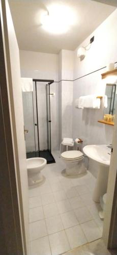 a bathroom with two toilets and two sinks at Hotel Milano San Giovanni Lupatoto in San Giovanni Lupatoto