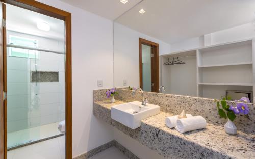 a bathroom with a sink and a mirror at Atlântida Park Hotel in Porto Seguro