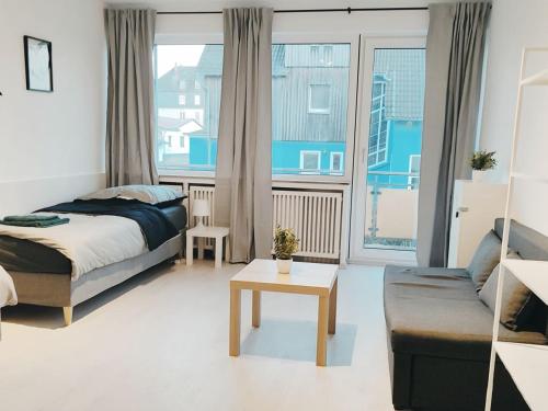 a bedroom with a bed and a couch and a table at Gleaming Apartment in Mettmann in Mettmann