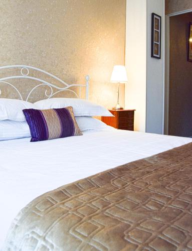 a bedroom with a large white bed and a lamp at Maison Deux in Abzac