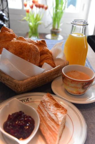 a table with bread and a bowl of jam and orange juice at Maison Deux in Abzac