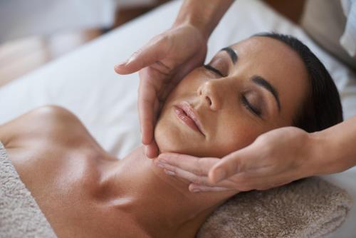 a woman getting her face rejuvenated by a massage therapist at PONTIANA Thalasso Hotel in Oropesa del Mar