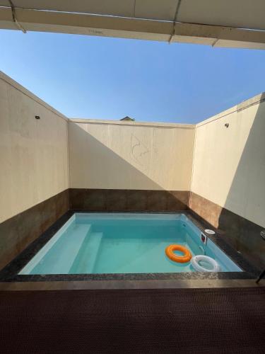 a swimming pool with an orange frisbee in it at Mango Shack Villa in Trimbak