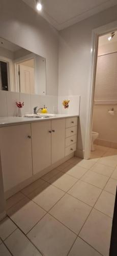 a white kitchen with a sink and a mirror at south Brighon 4 mins to beach near cafe shops in Brighton