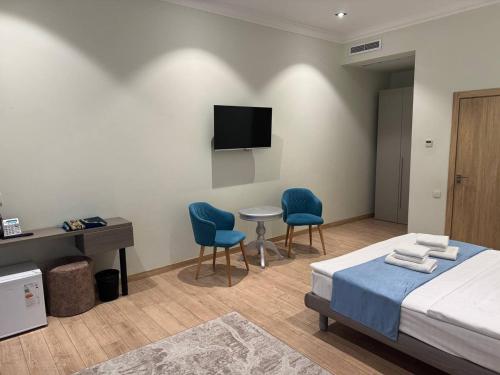 a bedroom with a bed and two chairs and a table at The Wood Hotel & Spa in Tashkent