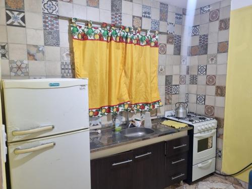 eine Küche mit einem weißen Kühlschrank und einer Spüle in der Unterkunft Costanera in Cafayate