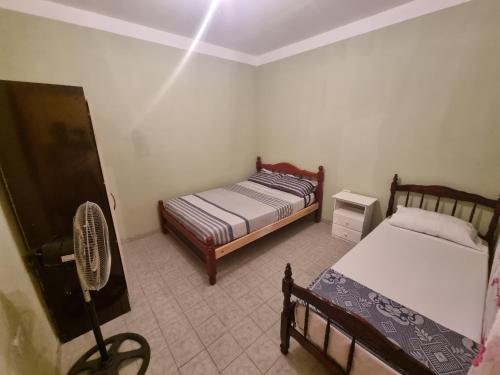 Kleines Zimmer mit 2 Betten und einem Ventilator in der Unterkunft Costanera in Cafayate