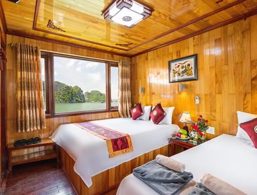 a bedroom with two beds and a window on a boat at Halong Ocean Cruise 6 in Ðảo Cát Bà
